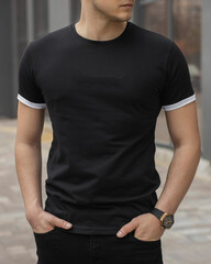 Stylish muscular men wearing black t-shirt posing on the street