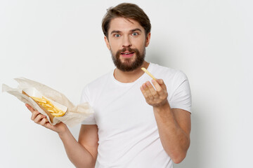 man with beard holding fries and high-calorie food Happy look model