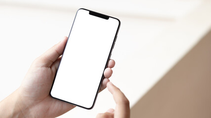 Hand holding and using smartphone with white blank on screen.