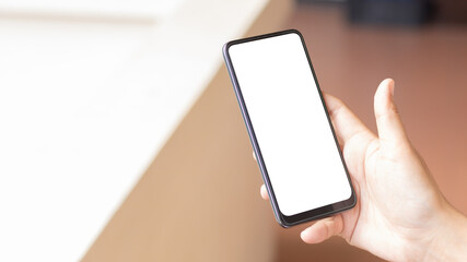 Hand holding and using smartphone with white blank on screen.