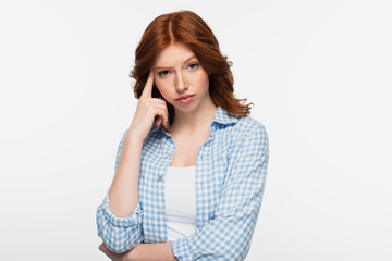 pensive redhead woman in blue plaid shirt isolated on white.
