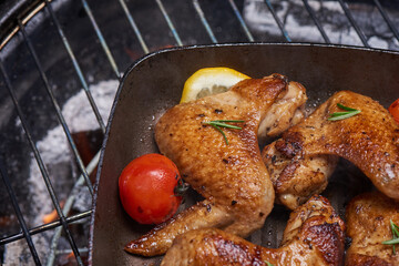 Grilled chicken wings on the flaming grill with Grilled vegetables in barbecue sauce with pepper seeds rosemary, salt. top view with copy space. tasty snack. Flat lay. Healthy lunch menu. Diet food.