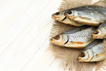 dry fish on a white wooden background with room for text.