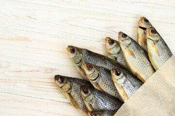 dry fish on a white wooden background with room for text.