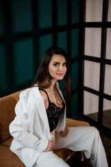 Fototapeta premium Fashion portrait of pretty sexy young brunette woman in white pantsuit