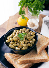
Dish of broad beans cooked in the Moroccan style. Plate of homemade food. Moroccan-style legumes with spices, lemon and parsley. Food photography