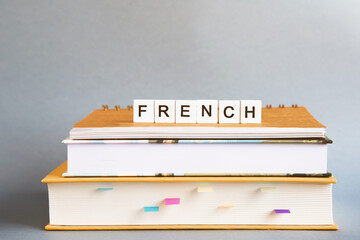 the inscription french on a stack of textbooks, books, exercise books, the concept of education and...