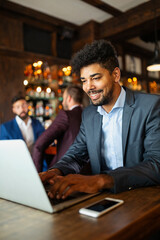 Handsome business man using laptop at his work break in restaurant