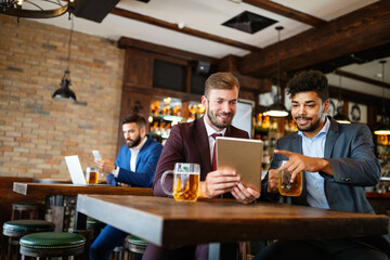 Business people drink beer after work. Businessmen enjoy a beer.