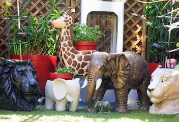 Safari Animal Planters and ornaments with a silver water fountain in the background, set on artificial Green Grass