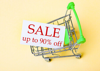 The card with the words SALE UP TO 90 OFF is in the shopping cart. Marketing concept
