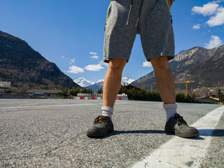 a man stands on a white lane near the mountains