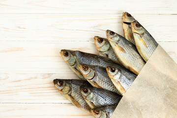 dry fish on a white wooden background with room for text.