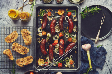 Delicious grilled sausages served on metal rusty tray. With barbecued vegetables