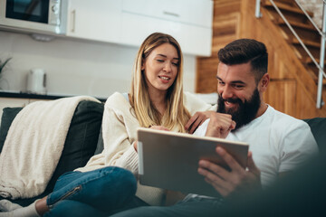 Couple using a digital tablet at home