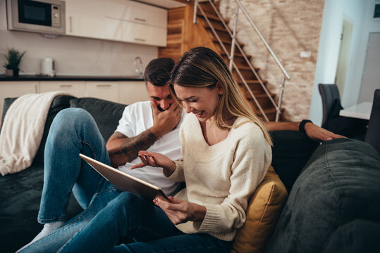 Couple using a digital tablet at home