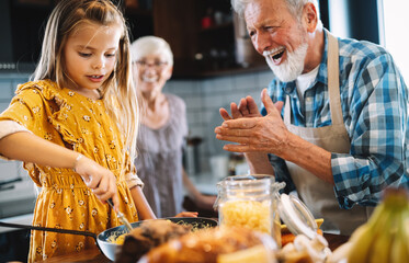 Smiling grandparents having breakfast with their granddaughter