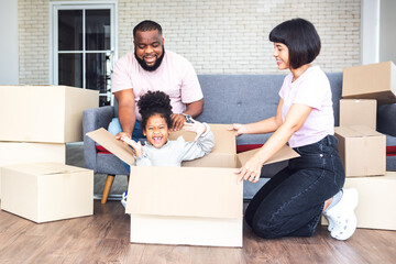 Fototapeta na wymiar Family, African American father, Asian mother and 5-year-old daughter, they are happy together From moving or relocation to a new home, to family and relationship concept.