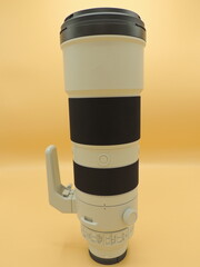 The telephoto lens is gray for the camera . Yellow background. Macro photography.