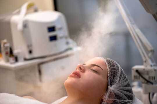 Beauty treatment of face with ozone facial steamer in beauty salon.