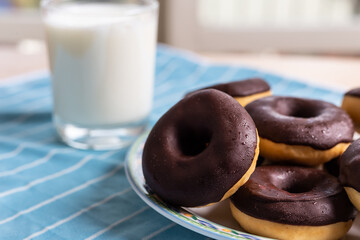 Chocolate donuts and milk, typical breakfast food.