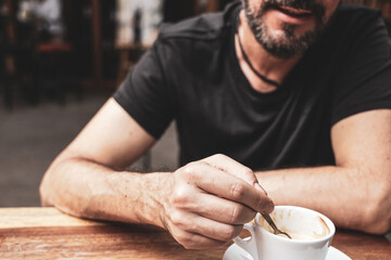 Bearded man is drinking coffee; close up, selective focus.
