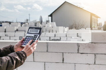 Calculation of building materials. woman calculates cost of building house. Calculator on...