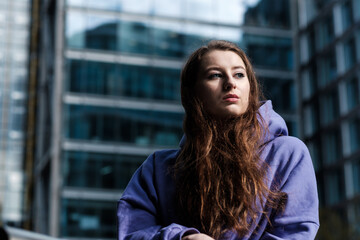 Portrait of a young woman in a purple hooded sweat, financial environment. Nostalgic.