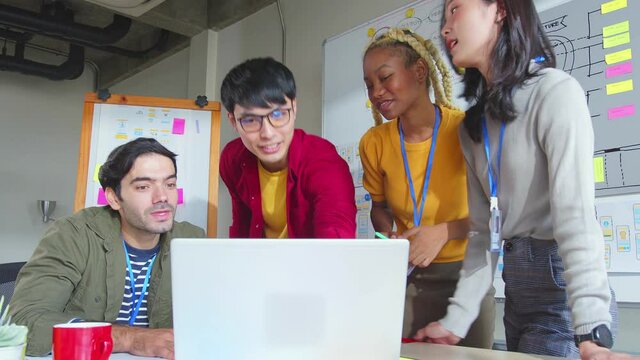Asian and caucasian staff creative senior designer coworkers success consulting in office on how to solve a problem as a team to young ux ui junior designer 