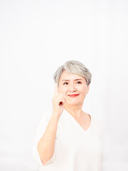 Senior asian woman pointing up 1 finger in white background.