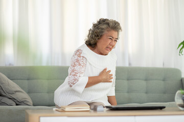 Emergency of Asian Elderly senior woman with white hairs sudden heart attack chest pain and illness on sofa at home,Elder Care Concept