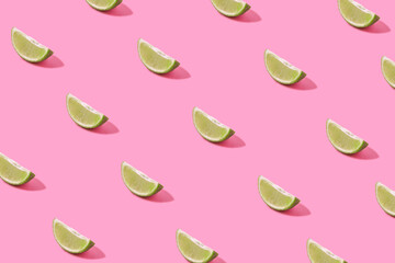 Colorful summer fruit pattern of lime slices on pink background. Top view. Flat lay.