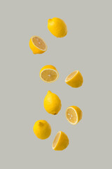 Creative sunlight summer arrangement with fresh yellow lemons against grey background. Minimal nature concept.