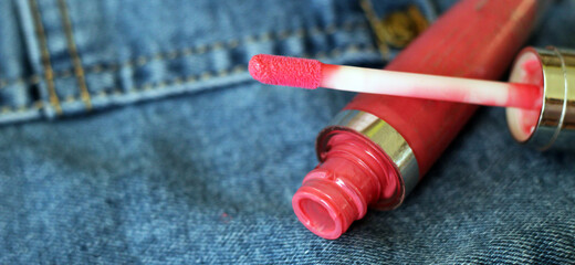 Fototapeta na wymiar Pink lip gloss and jeans
