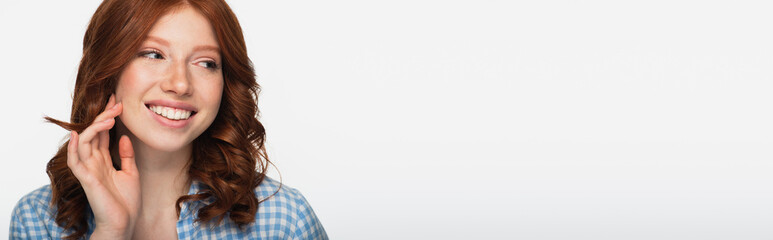 cheerful redhead woman in blue plaid shirt looking away isolated on white, banner.