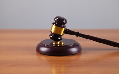 Hammer of a judge, a pair of wedding rings on a wooden background. Family law. Divorce.