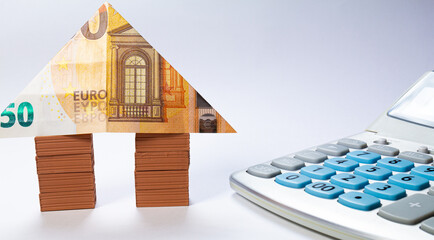 House made of brick stacks with a 50 euro note as a roof. Home loan real estate for mortgage concept.