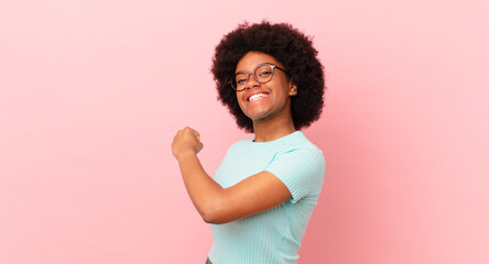 afro black woman feeling happy, positive and successful, motivated when facing a challenge or...