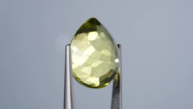 natural yellow citrine in the tweezer on the turning table