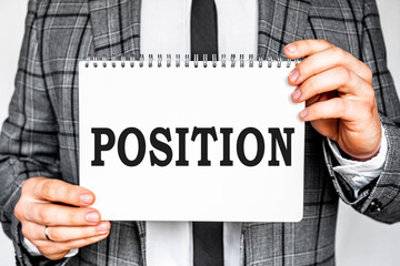 business, technology, internet and networking concept - businessman in gray fashionable business suit holding a white notebook with conference inscription POSITION inscription