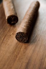 Group of brown cuban cigars on wooden background