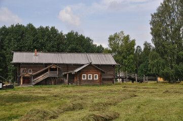 Panorama, a large old log house in the meadow. 03 August 2020 Arkhangelsk, Russia.