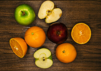 Orange and apple slices on a wooden board. top view
