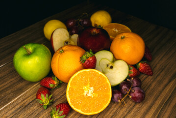 Fototapeta na wymiar fresh fruits on a wooden board on a black background