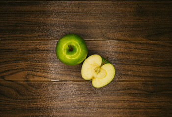 green apple slice with water drops on a wooden board. top view