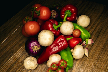 tomatoes, mushrooms, red and green pepper, onion and garlic on a black background. Mediterranean food