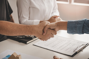 Close up hand of home, apartment agent or realtor handshake with newlandlord, tenant or rental. After the banker has approved and signed the purchase contract agreement successfully. Property concept.