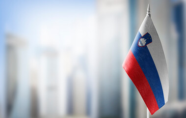 A small flag of Slovenia on the background of a blurred background