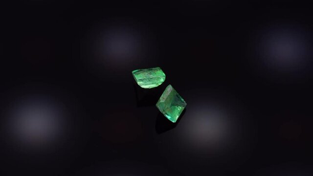 natural green emerald on the turning table on the black background