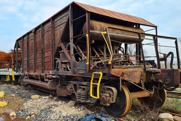 Abandoned old rusty freight industrial wagon on a factory railroad at sunny day.